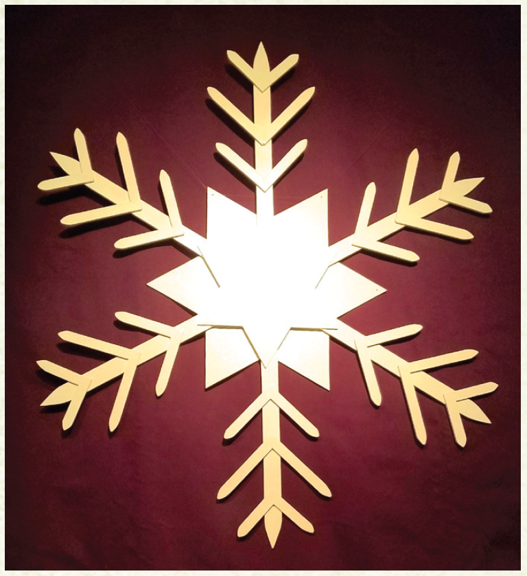 Gold star/snowflake against maroon background