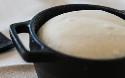Bread being baked in a cast iron pot.