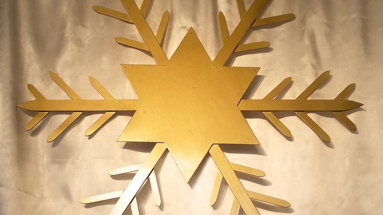 Gold star/snowflake against white background