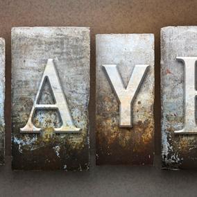 "prayer" spelled out in metal type