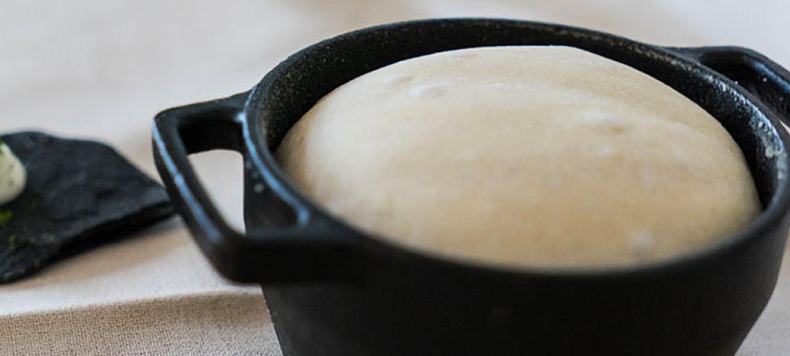 Bread being baked in a cast iron pot.