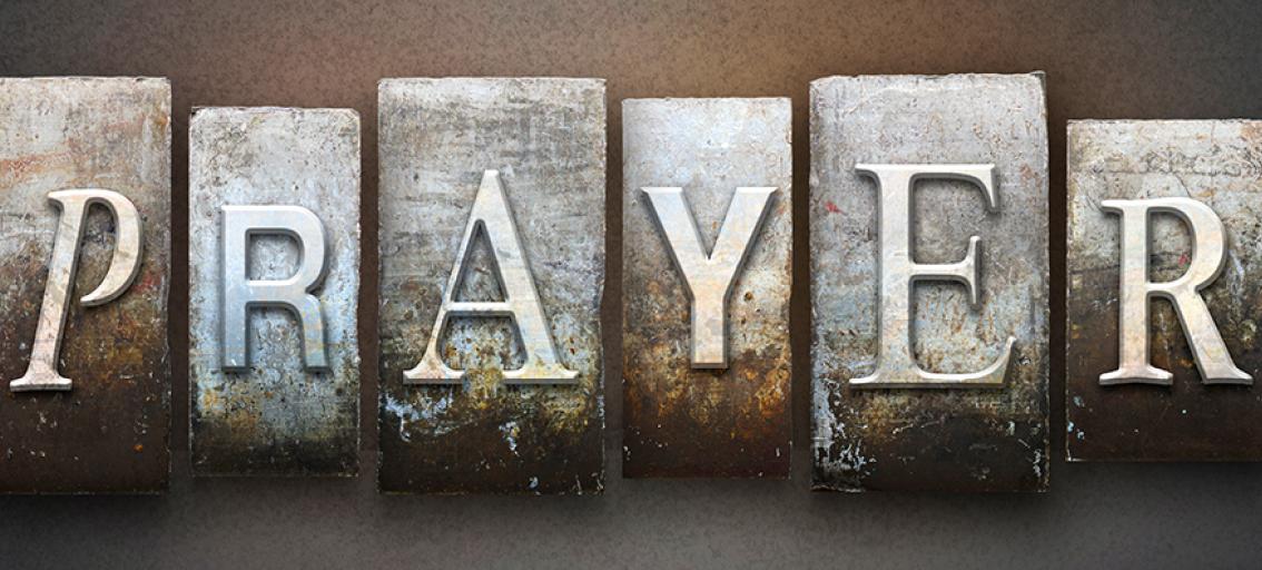 "prayer" spelled out in metal type