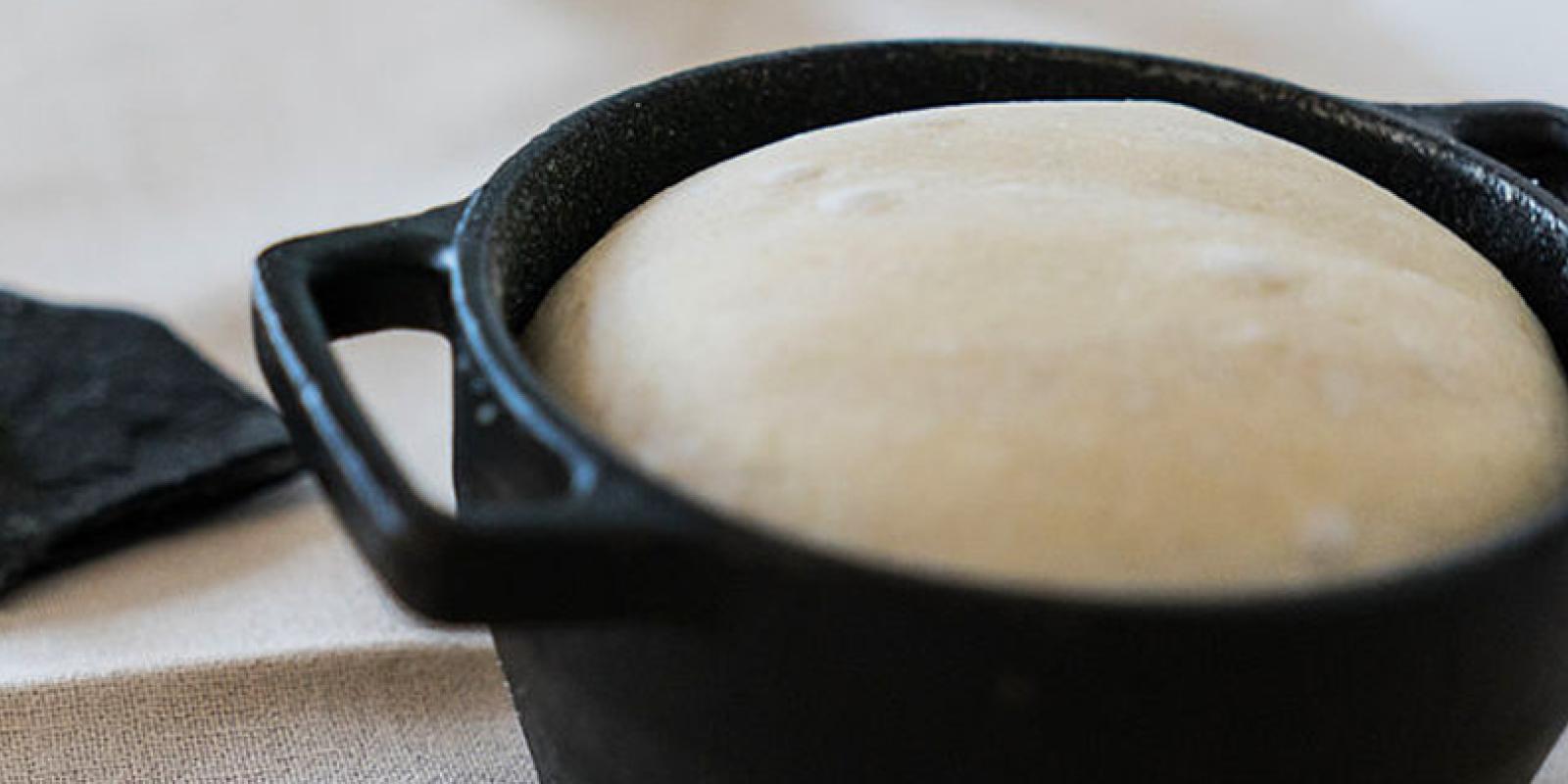 Bread being baked in a cast iron pot.