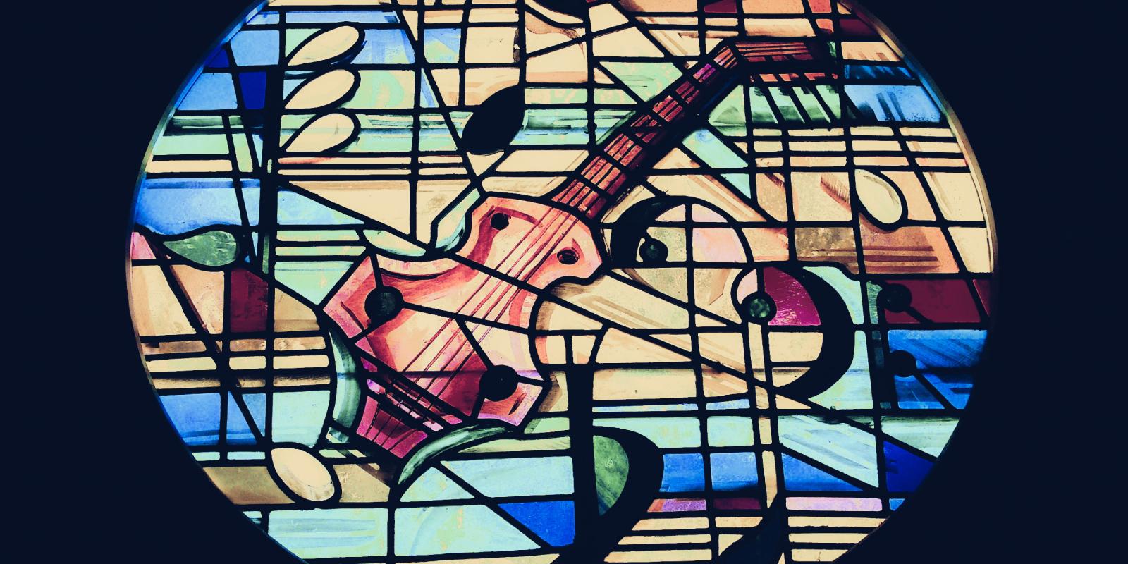 Stained glass window with stringed instrument and music symbols